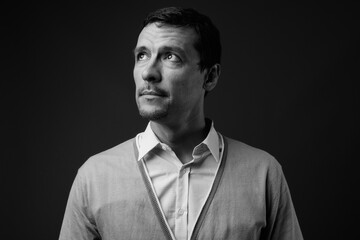 Portrait of handsome man with beard stubble against gray background