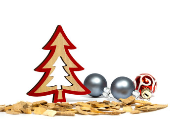 Christmas decorations: Christmas tree made of natural material, glass Christmas balls, red and silver colors among wood chips. Close-up, selective focus, white background