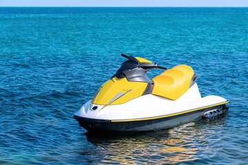 Yellow white jet ski moored in the blue sea. Nobody, only jet ski. Active rest on a jet ski. Extreme