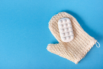 massage soap and washcloth mitten on blue background