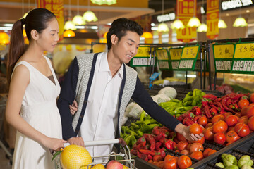 Fototapeta premium A young couple in the supermarket shopping