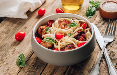Italian pasta with chicken meatballs, tomatoes and basil.