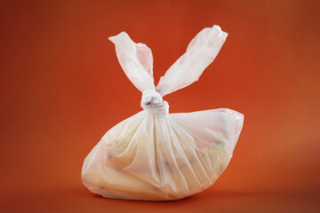 plastic bag with fruits agains orange background, zero waste and environment  pollution concept