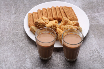 cutting masala chai or tea served with puff pastry/ khari and biscuits.