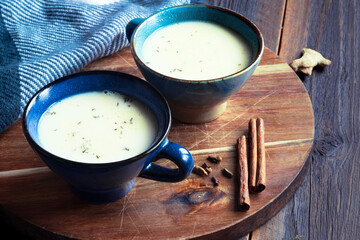 traditional indian masala tea with spices on wooden board