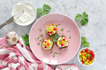 Canape or crostini with toasted bread, light cheese and colorful bell pepper. Top view with copy space.