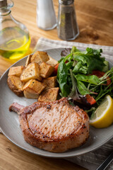 grilled pork chop with potato and salad