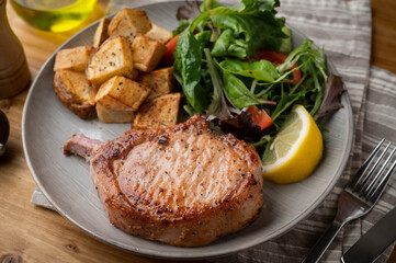 grilled pork chop with potato and salad