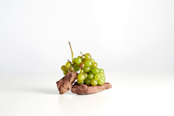green grape and Vulcano stone on the white table balance. High quality photo