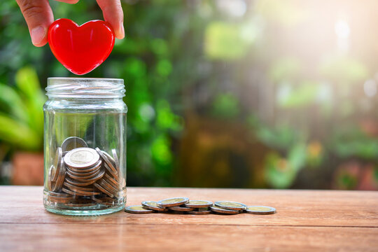 putting heart model on saving bottle for concept donation and philanthropy