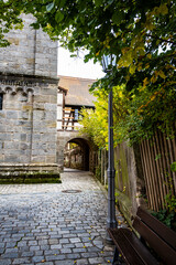 Timber frame & old stone church with arch walkway and cobblestone street. Taken in autumn / fall in Feuchtwangen, Germany