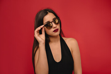 Beautiful brunette model girl with long hair. Red lips and nails manicure . Fashion , beauty and make up portrait