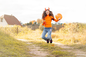 Halloween kids. Portrait of smiling girl with brown hair running and jumping.