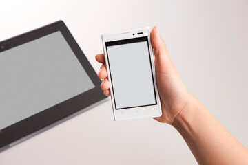 スマートフォンを持つ手とタブレット