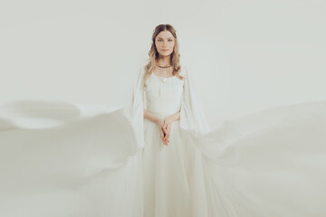 Fototapeta premium Stylish woman in white silky dress portrait