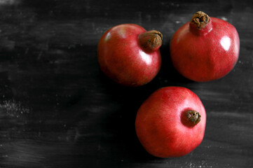 Fototapeta na wymiar Ripe red pomegranates. Seasonal fruits. Royal fruit.