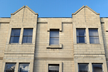Fototapeta na wymiar Facade of New Concrete Block Apartment Building against Blue Sky 