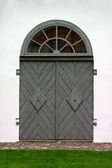A beautifully restored gray wooden door in an old barn.