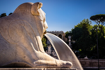 la fontana dei leoni in piazza del popolo fa da cornice alla fontana della dea roma, alle prime luci del giorno - obrazy, fototapety, plakaty