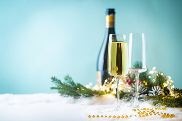 Champagne glasses and christmas decor on blue sparkling holiday background