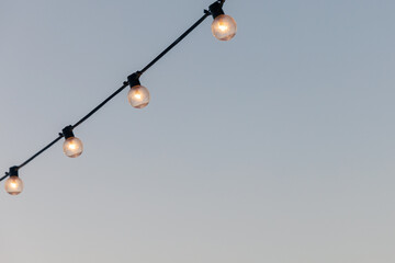 light bulbs garlands on a background of blue sky.