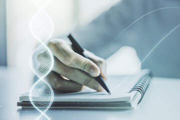 Creative DNA sketch and man hand writing in notepad on background, biotechnology and genetic...