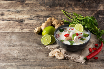 Traditional Thai food Tom Kha Gai and ingredients on wooden table. Copy space