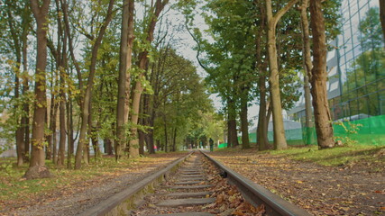 The young man in stylish clothes crosses the track. The man in the hood walks past the camera and does not look back.