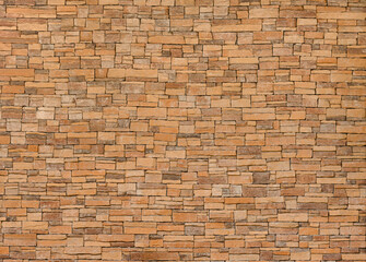 Fototapeta premium background and texture of yellow decorative stone wall surface.