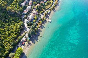 Pure Turquoise water at Ohrid lake in Macedonia drone shot from 300 meters small port and a few village houses around