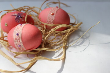 easter eggs in a nest in pink color and decoration for Easter card background