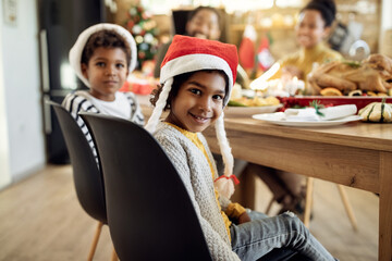 Cute African American girl enjoying with her family in dining room on Christmas.