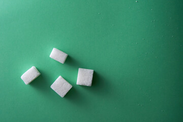 top view of white sugar cube on green background