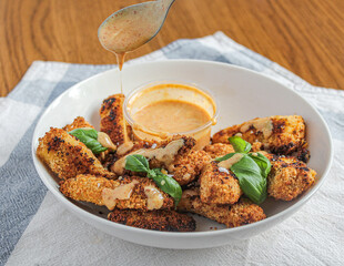 Chicken fingers. Breaded and oven-baked honey mustard chicken bites. Appetisers in a bowl with a...