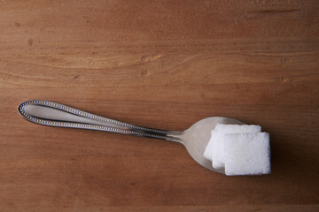 top view spoon of white sugar cubes