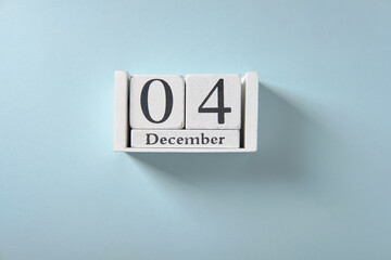 ? Wooden white calendar on blue background, date 4 December.