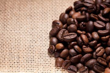 roasted coffee beans, (selective focus on coffee beans), with background raffia sack