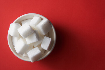 top view of white sugar cube on red background