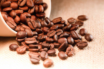 roasted coffee beans, (selective focus on coffee beans), raffia sack background