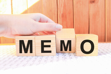 the hand of a man in a business suit holds cubes with the word MEMO business concept written on them. business and Finance