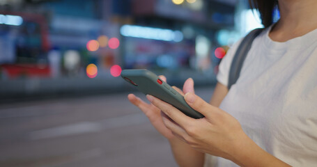 Woman use of mobile phone in city at night