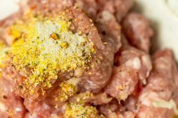 Fresh minced pork sprinkled with salt, seasoning close-up. Background of minced pork.