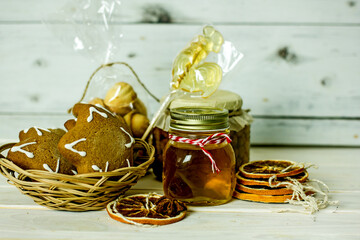 Homemade Christmas Food Gifts.Homemade cookies nuts, gingerbread, a jar of honey, dried oranges, a mixture for baking cookies in a jar on a wooden background. The concept of cozy, soulful DIY gifts