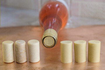Synthetic wine corks on the background of a corked bottle of rose wine.