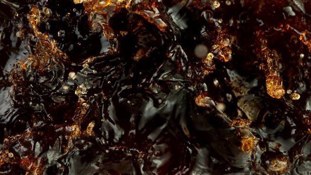 Super slow motion of splashing cola drink or ice tea. Filmed on high speed cinema camera, 1000 fps.