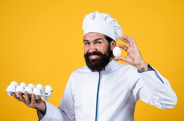 professional restaurant bearded cook man hold eggs, healthy eating