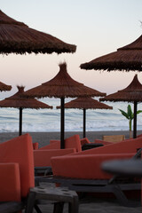 Straw umbrella on the beach with sun loungers on the coast of Malaga