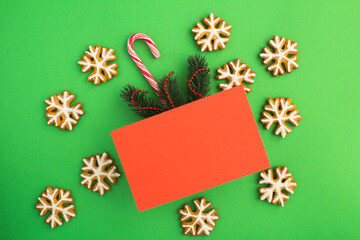 Top view of Christmas gift and gingerbread on the green background