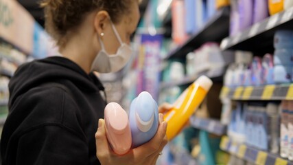 Hoarding during covid 19 outbreak. Caucasian woman in face mask shopping for products in store to...