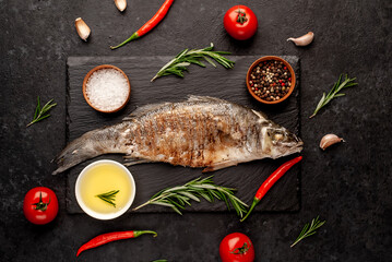 grilled sea bass fish with spices on a stone background